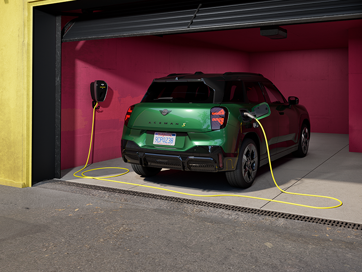 Täiselektriline British Racing Greeni värvitoonis MINI Aceman garaažis laadimas, tagantvaade.