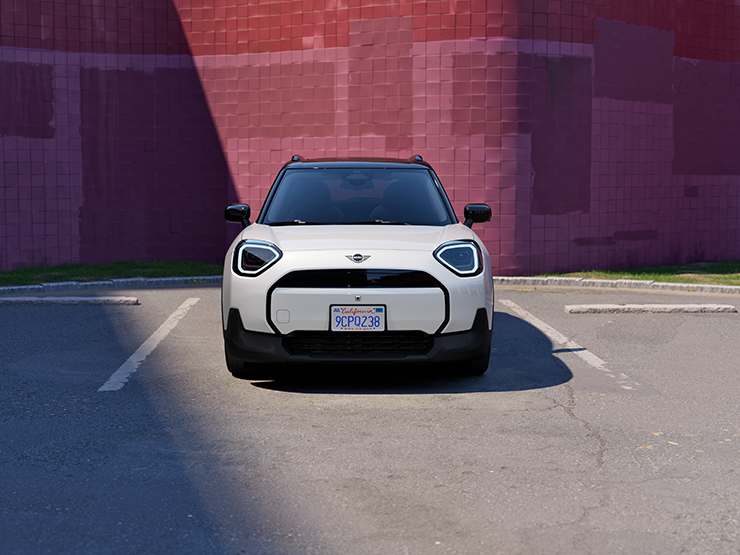 Täiselektriline Nanuq White’i värvitoonis ja musta katusega MINI Aceman parkimas, eestvaade.