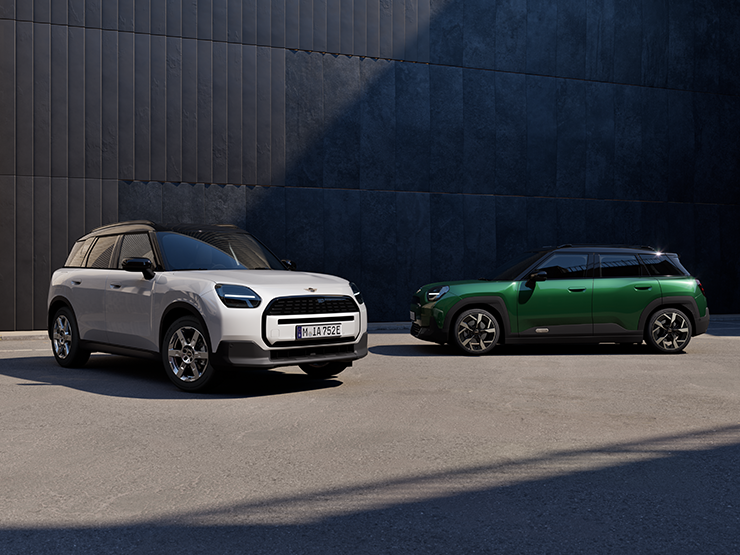 Täiselektriline Nanuq White’i ja British Racing Greeni värvitoonis ning musta katusega MINI Aceman tänaval, eest- ja külgvaade.