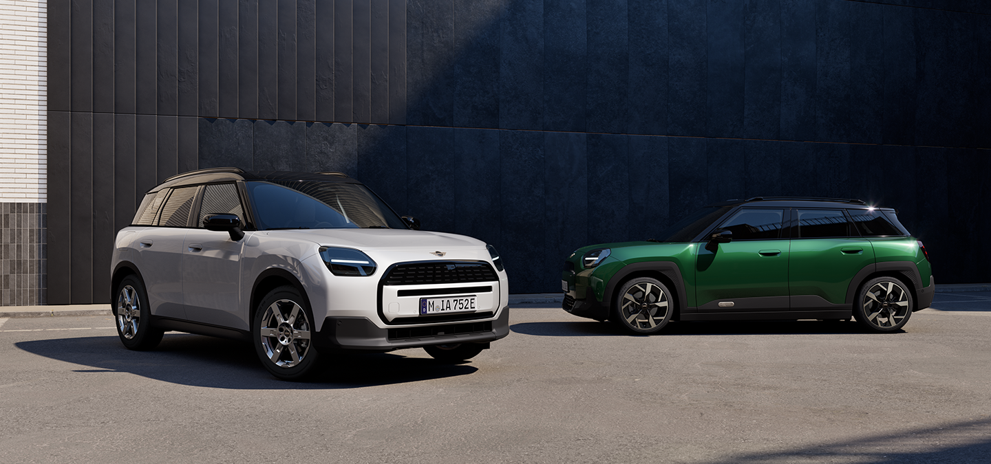 Täiselektriline Nanuq White’i ja British Racing Greeni värvitoonis ning musta katusega MINI Aceman tänaval, eest- ja külgvaade.