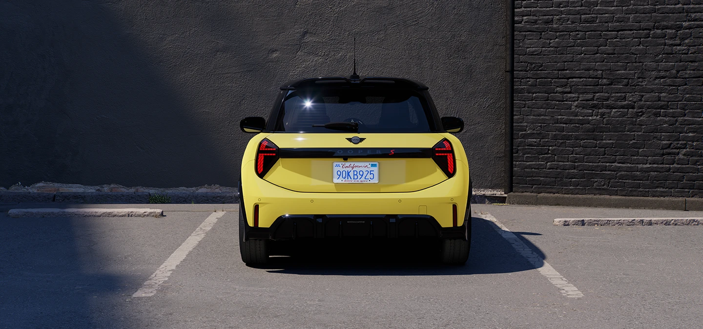 Sunnyside Yellow värvitoonis ja musta katusega MINI Cooper parkimas, tagantvaade.