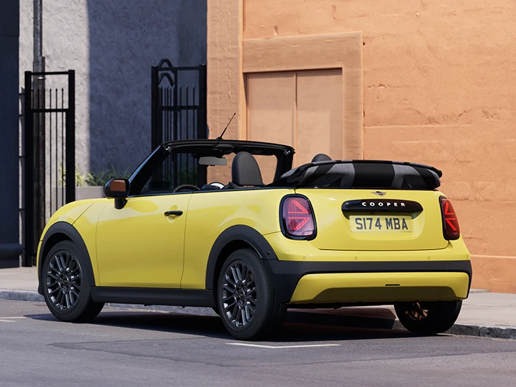 Tagantvaade vasakult: parkiv MINI Cooper Convertible värvitoonis Sunnyside Yellow