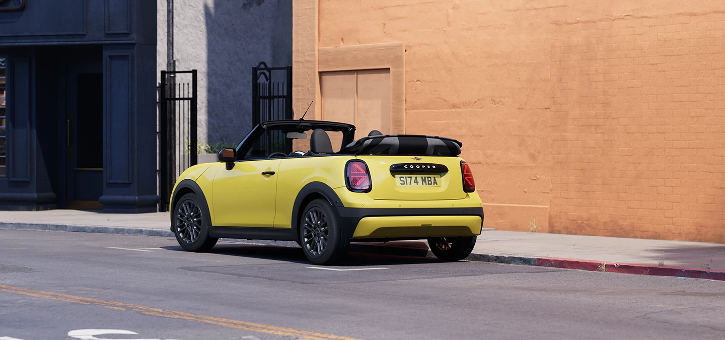 Tagantvaade vasakult: parkiv MINI Cooper Convertible värvitoonis Sunnyside Yellow