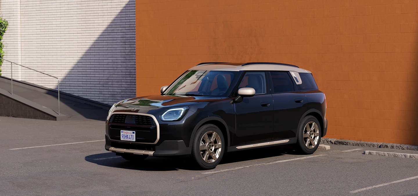Eest külgvaade Midnight Blacki värvitoonis ja Vibrant Silveri katusega MINI Countrymanile parkimas.