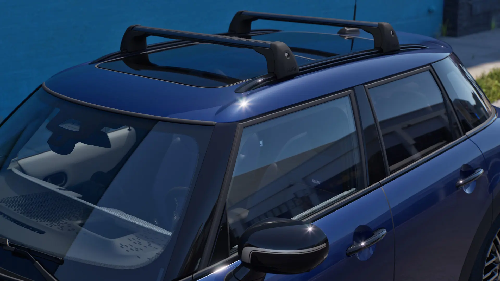 MINI Aceman eest ja küljelt lähivaates värvitoonis Indigo Sunset Blue, varustatud MINI katuseraamiga.