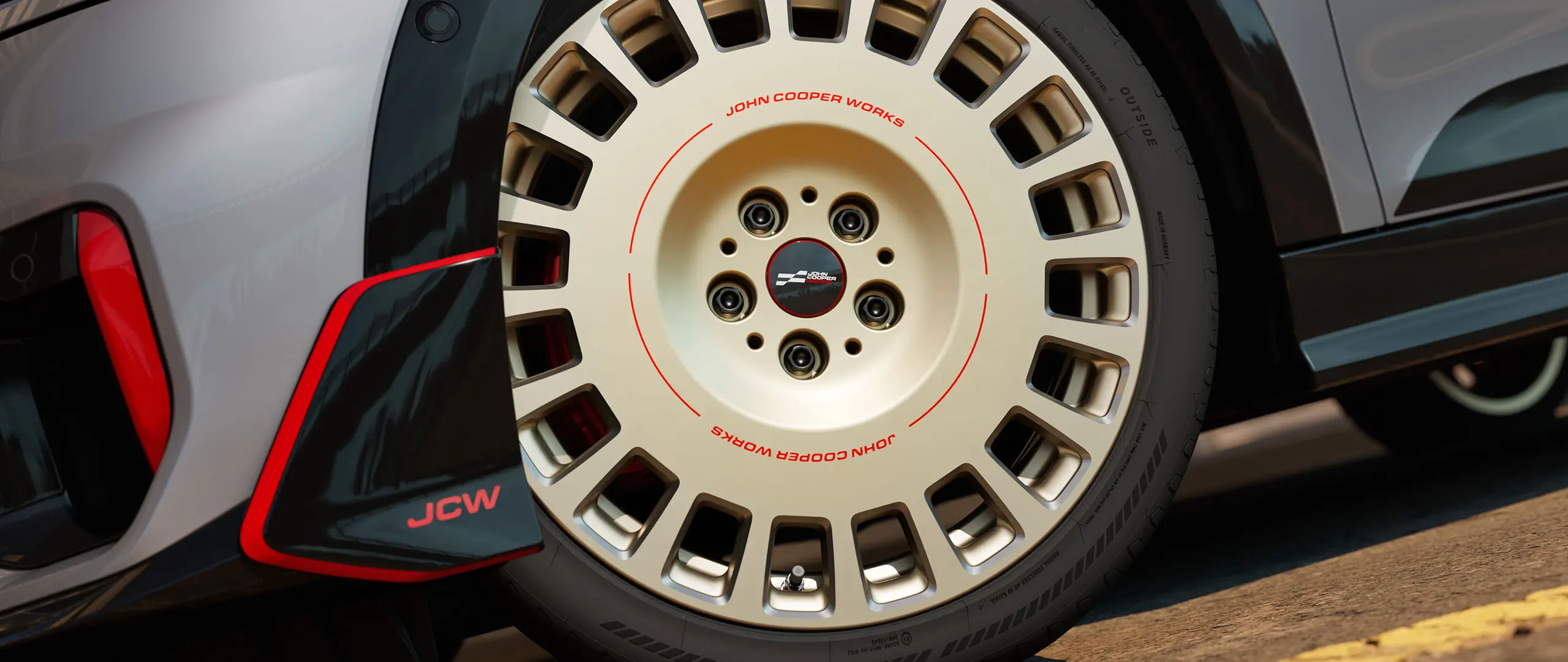 Lähivaade 18-tollisele teemantlihvitud JCW Rallye Spoke 964 veljele värvitoonis Bicolour Vibrant Silver ja tiivakesele.