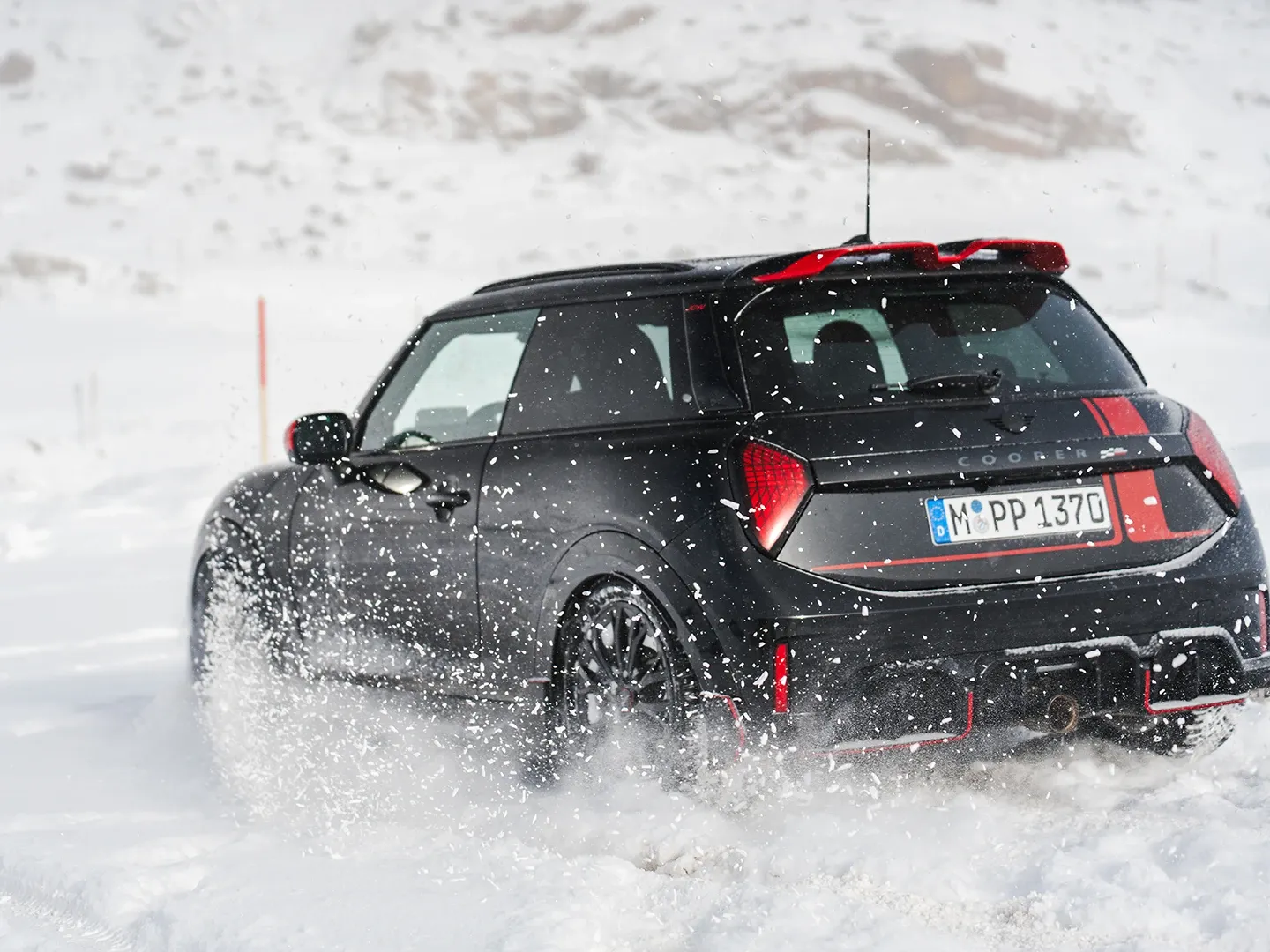 MINI Cooper JCW tagantvaade lumes sõitmas.