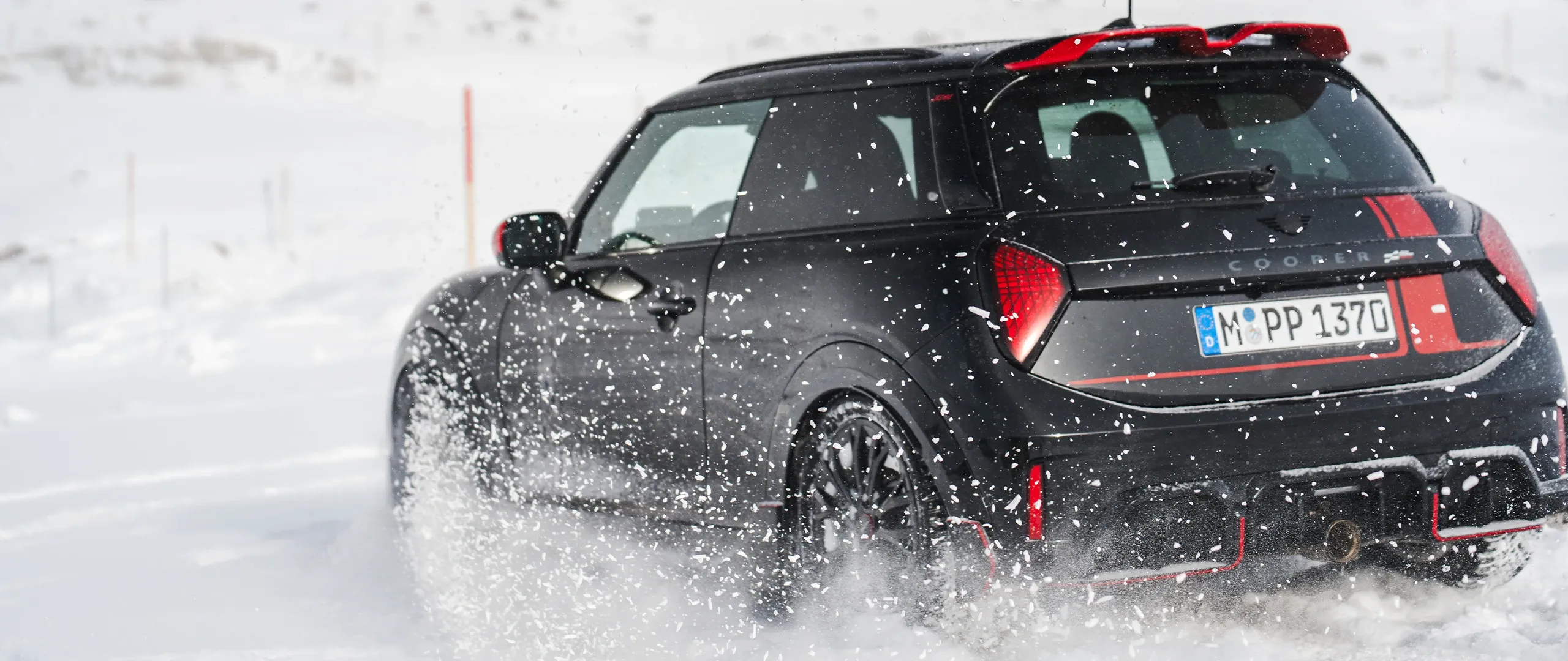 MINI Cooper JCW tagantvaade lumes sõitmas.