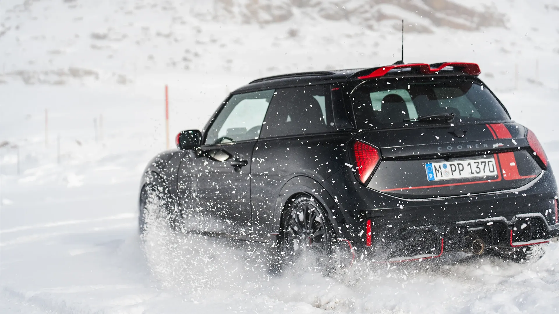 MINI Cooper JCW tagantvaade lumes sõitmas.
